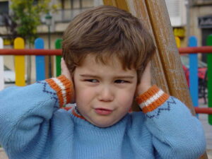 boy with hands over ears